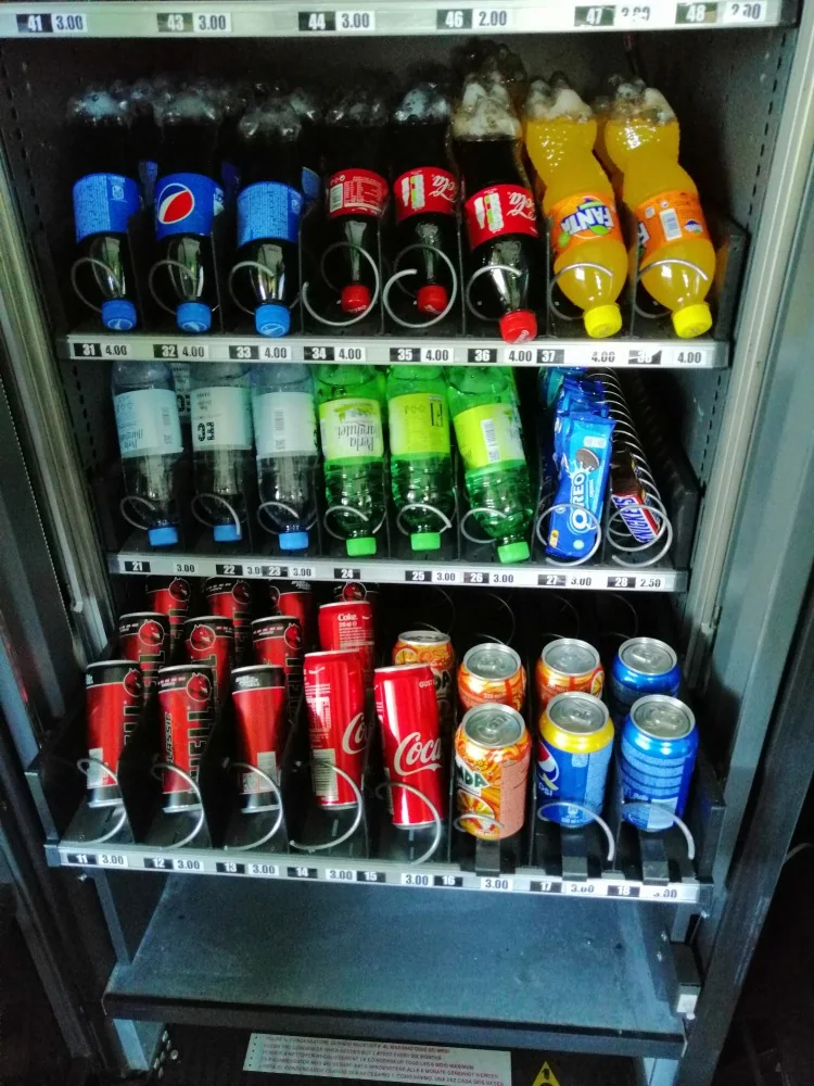 Raftul de băuturi reci al unui automat: sticle PET și doze